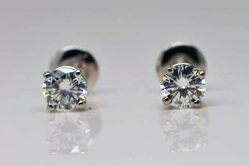 Image of a pair of studs - An experiment. One is a recycled diamond, and the other is a moissanite set in recycled platinum. .