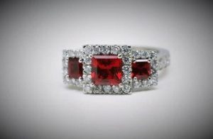 Top view of platinum trilogy ring showing synthetic rubies surrounded by white accent diamonds