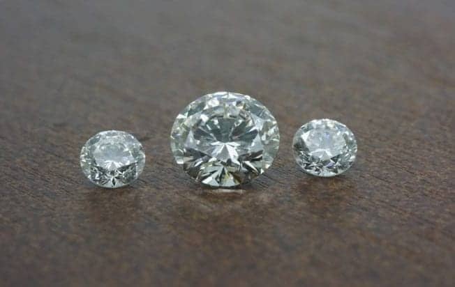 Image of three diamonds. These are CVD lab created diamonds. A centre half carat GVS with 3mm G/H Si side diamonds.