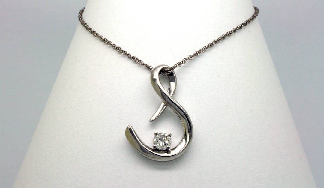 Photo of a S shaped pendant made with white gold and a diamond recovered from a customer's late wife's rings