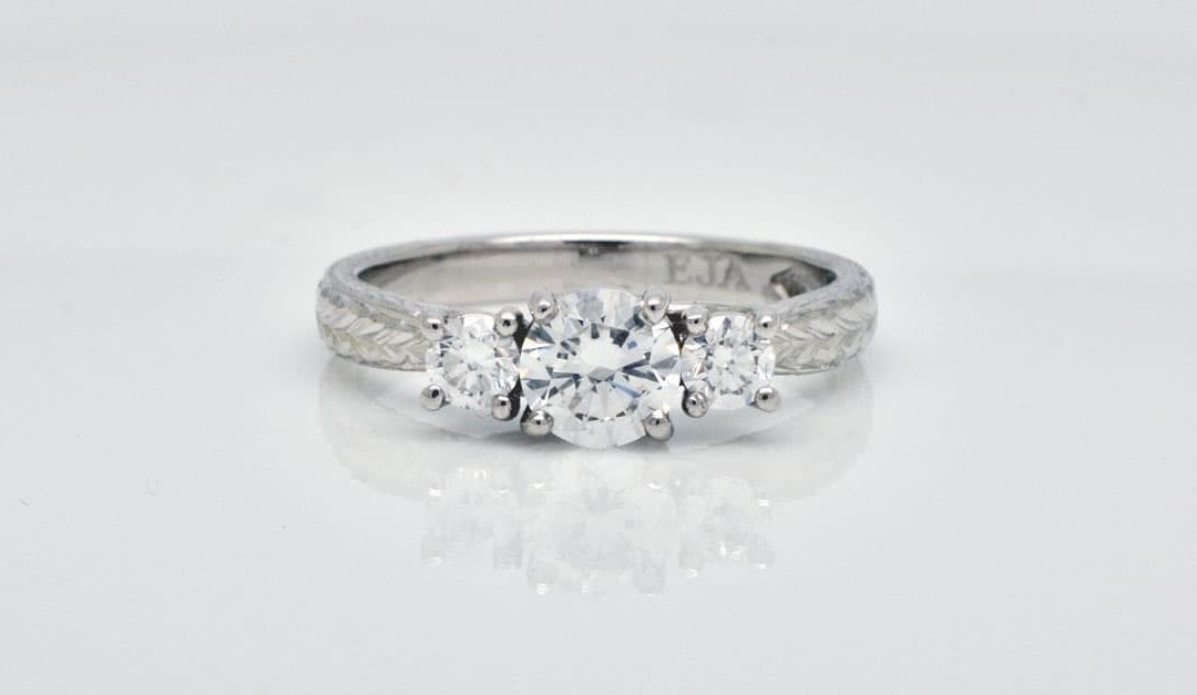 Photo of a lab-diamond, trilogy style ring made with recycled platinum