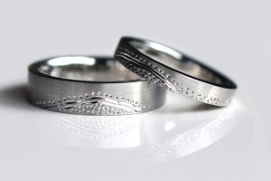 Matched pair of platinum wedding rings featuring aboriginal art-inspired engraving